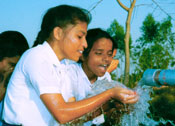Girls drinking water from well
