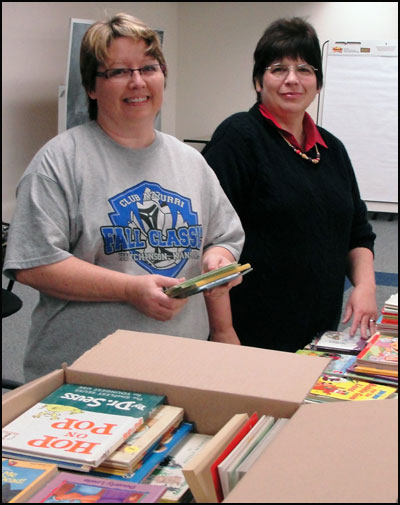 Two volunteers packing books